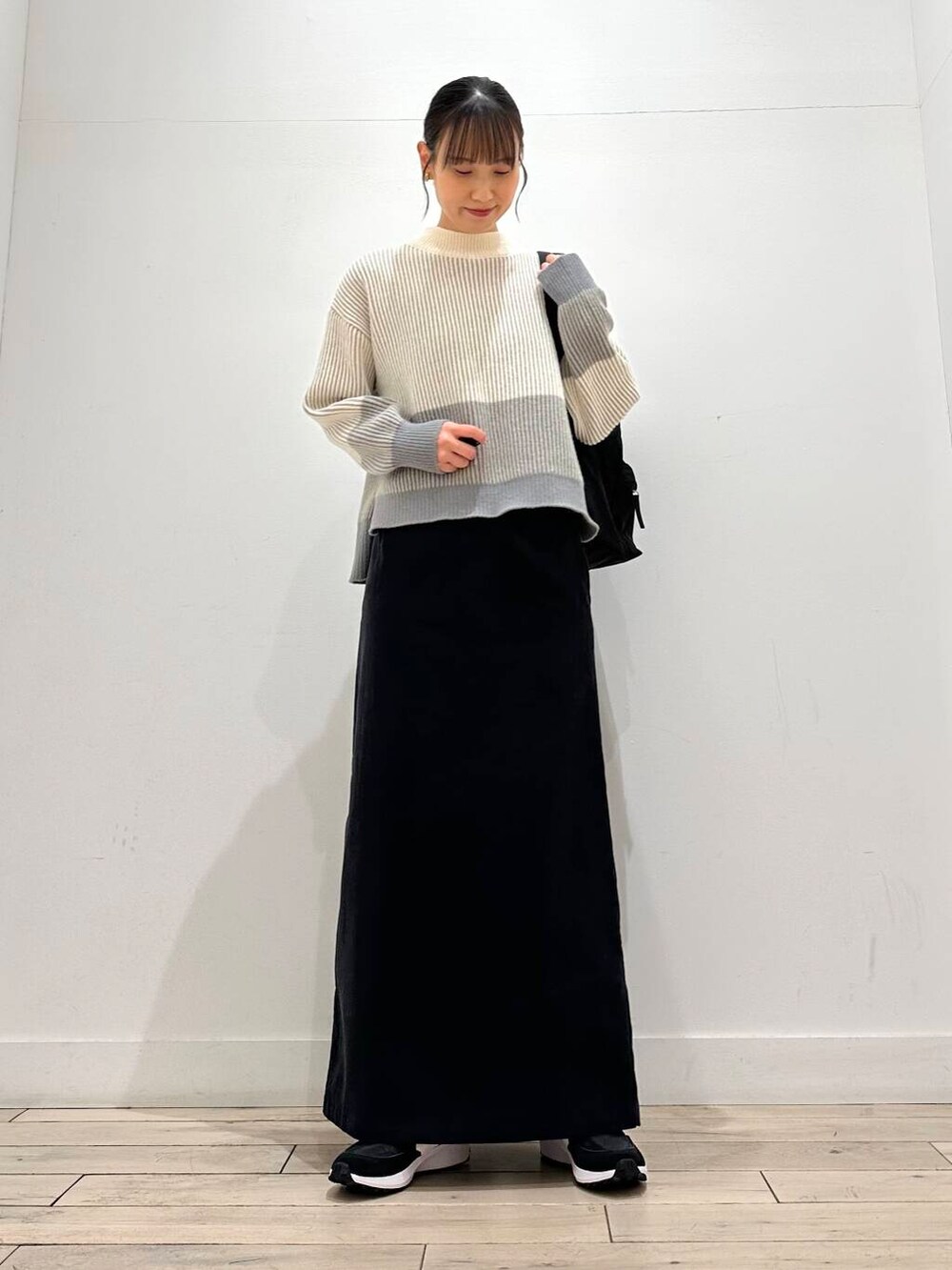 グレー系のその他アウター、グレー系のスカート、ブラック系のバックパック/リュックを着用したレディースの冬コーディネートの3枚目の写真