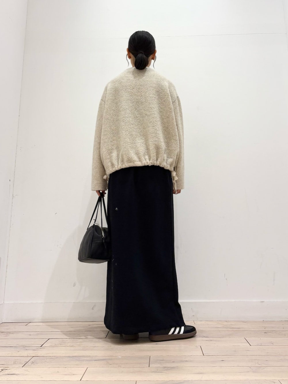 ベージュ系のTシャツ/カットソー、ブラック系のボストンバッグ、ブラック系のスニーカーを着用したレディースの秋コーディネートの3枚目の写真