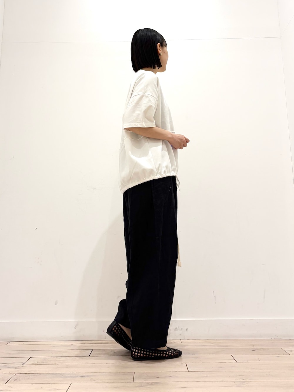 ホワイト系のTシャツ/カットソー、ブラック系のその他パンツ、ブラック系のサンダルを着用したレディースの春コーディネートの3枚目の写真