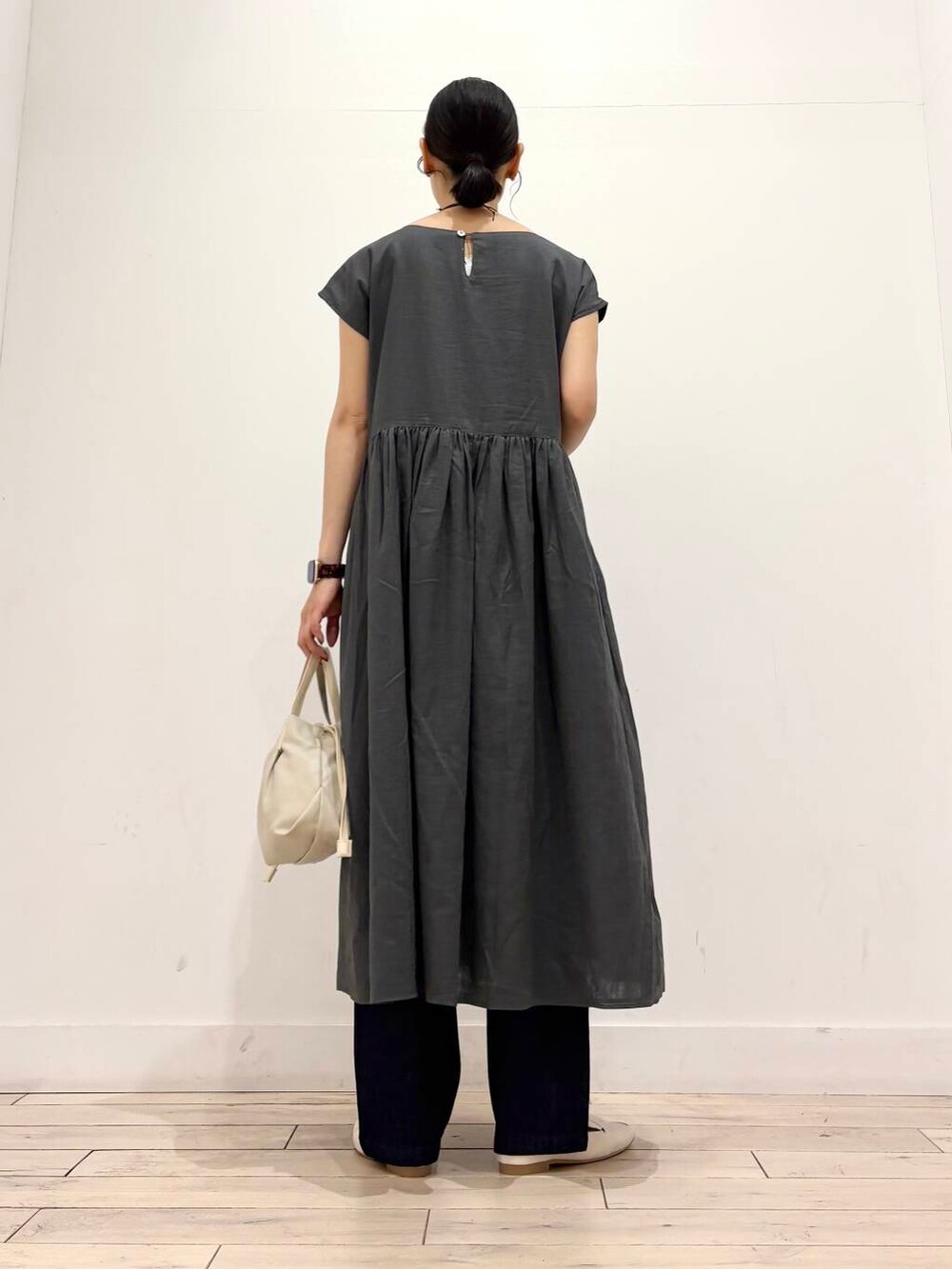 ホワイト系のローファー、ブルー系のデニムパンツ、グリーン系のワンピースを着用したレディースの夏コーディネートの4枚目の写真