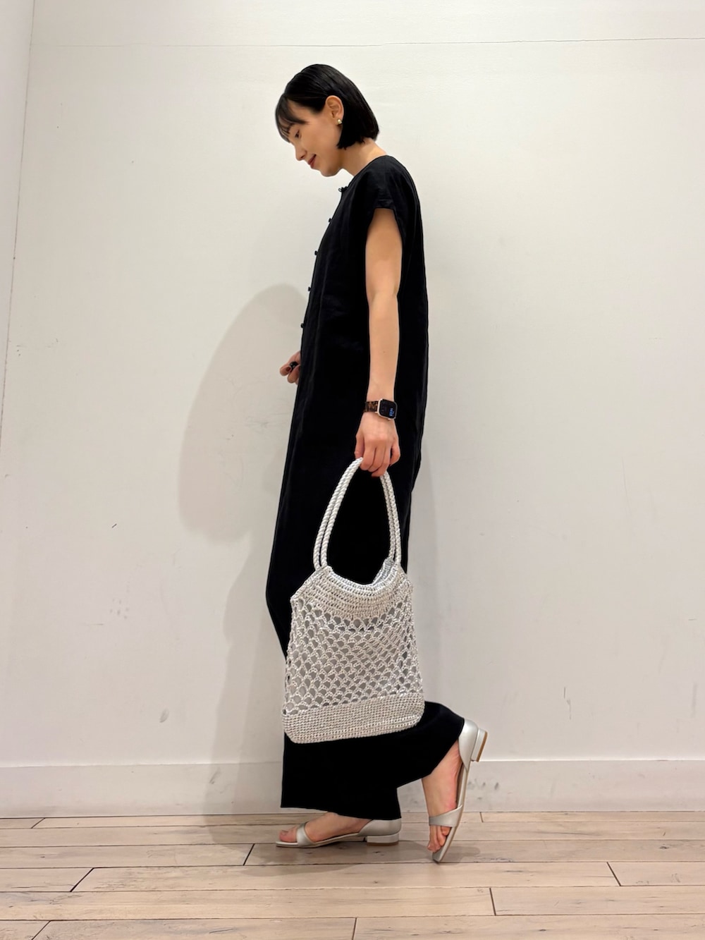 シルバー系のトートバッグ、シルバー系のサンダル、ブラック系のつなぎ/オールインワンを着用したレディースの春コーディネートの4枚目の写真