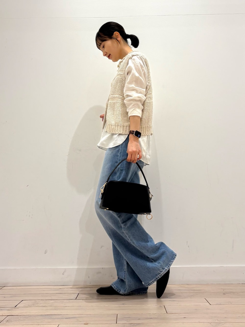 ホワイト系のシャツ/ブラウス、ホワイト系のベスト、ブラック系のショルダーバッグを着用したレディースの春コーディネートの4枚目の写真