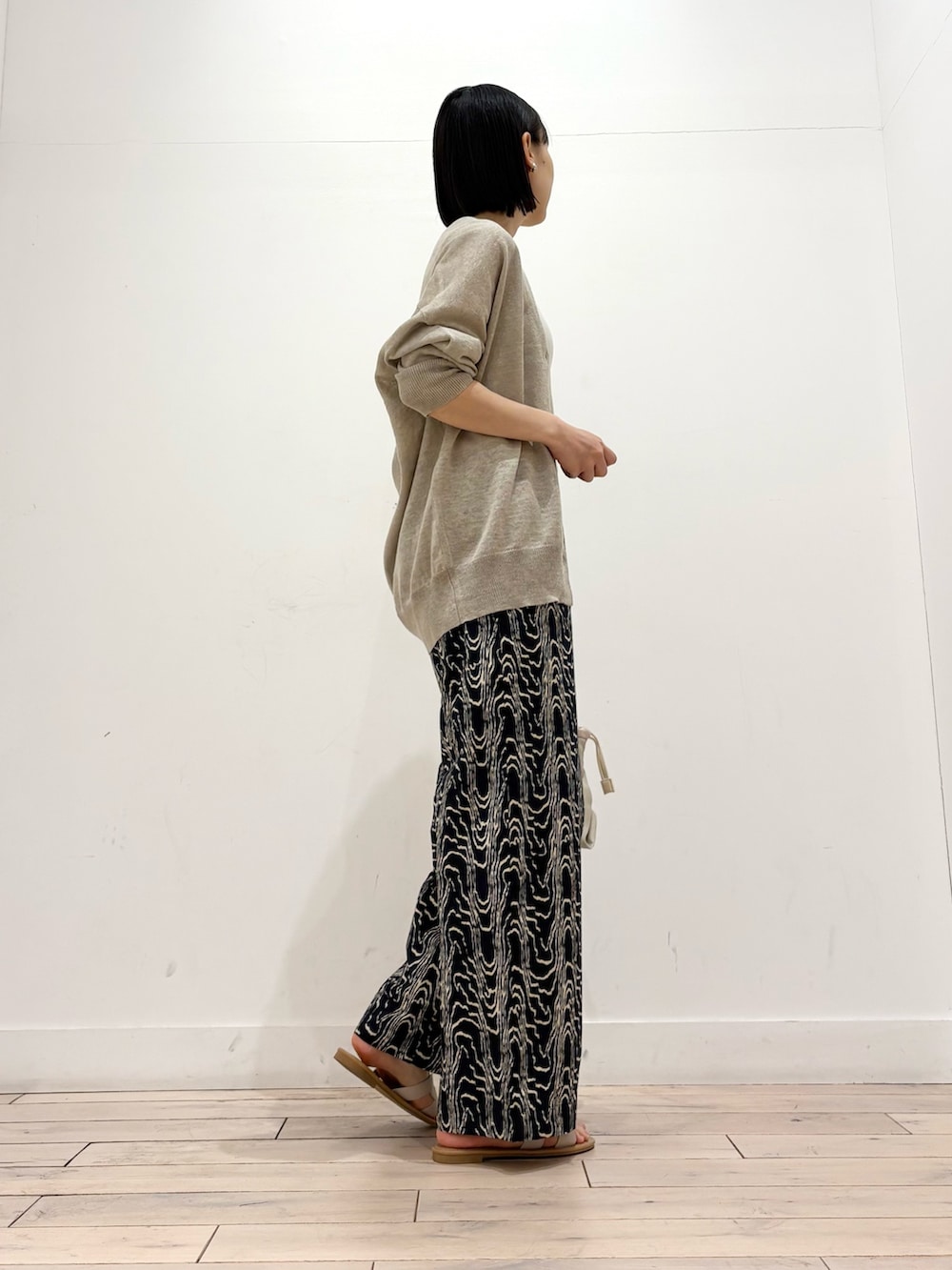 ホワイト系のタンクトップ、ベージュ系のカーディガン/ボレロ、ブラック系のその他パンツを着用したレディースの春コーディネートの5枚目の写真