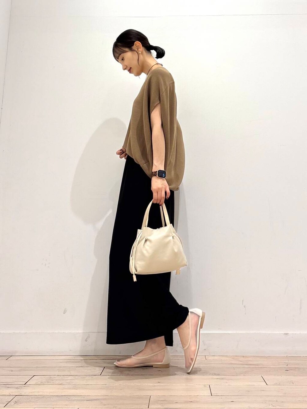 ホワイト系のバレエシューズ、ブラック系のスカート、ホワイト系のショルダーバッグを着用したレディースの夏コーディネートの3枚目の写真