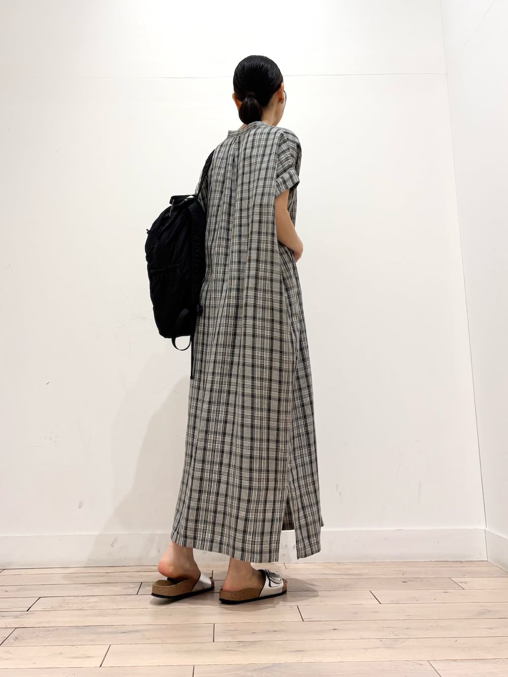 グレー系のワンピース、ブラック系のバックパック/リュック、シルバー系のサンダルを着用したレディースの夏コーディネートの3枚目の写真
