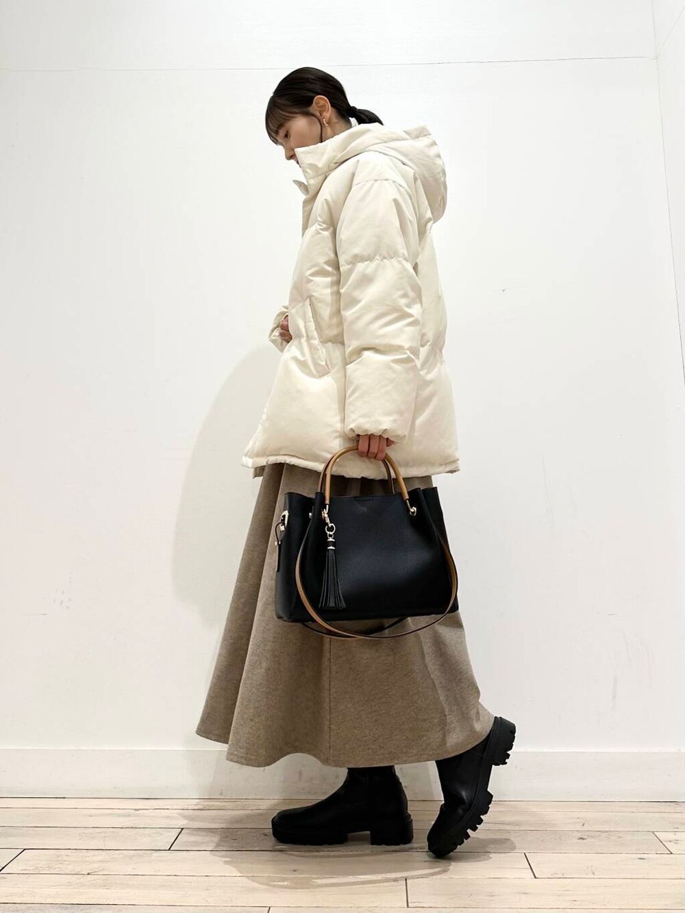 ブラック系のトートバッグ、ブラック系のブーツ、その他のニット/セーターを着用したレディースの冬コーディネートの5枚目の写真