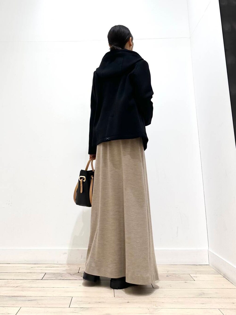 ブラック系のトートバッグ、ブラック系のその他アウター、ブラック系のブーツを着用したレディースの冬コーディネートの6枚目の写真