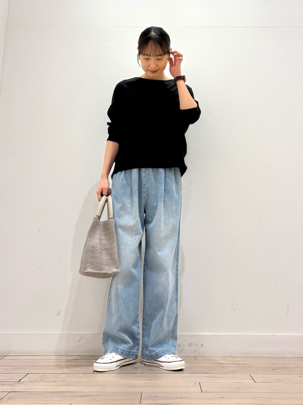 ブラック系のTシャツ/カットソー、グレー系のハンドバッグ、ブルー系のデニムパンツを着用したレディースの春コーディネートの2枚目の写真