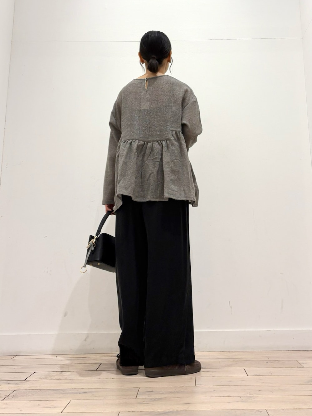 グレー系のシャツ/ブラウス、ブラウン系のスニーカー、ブラック系のショルダーバッグを着用したレディースの秋コーディネートの4枚目の写真