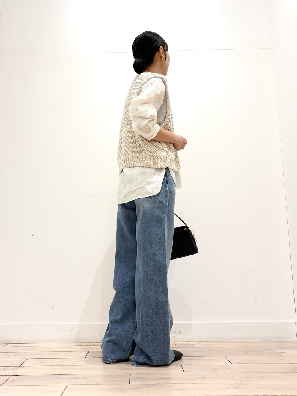 ホワイト系のシャツ/ブラウス、ホワイト系のベスト、ブラック系のショルダーバッグを着用したレディースの春コーディネートの5枚目の写真