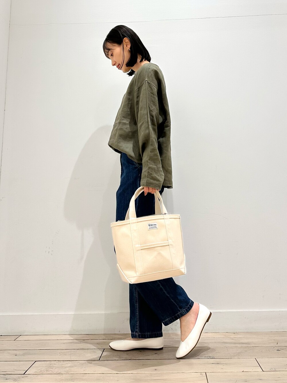 グリーン系のシャツ/ブラウス、ブルー系のデニムパンツ、ホワイト系のパンプスを着用したレディースの春コーディネートの2枚目の写真