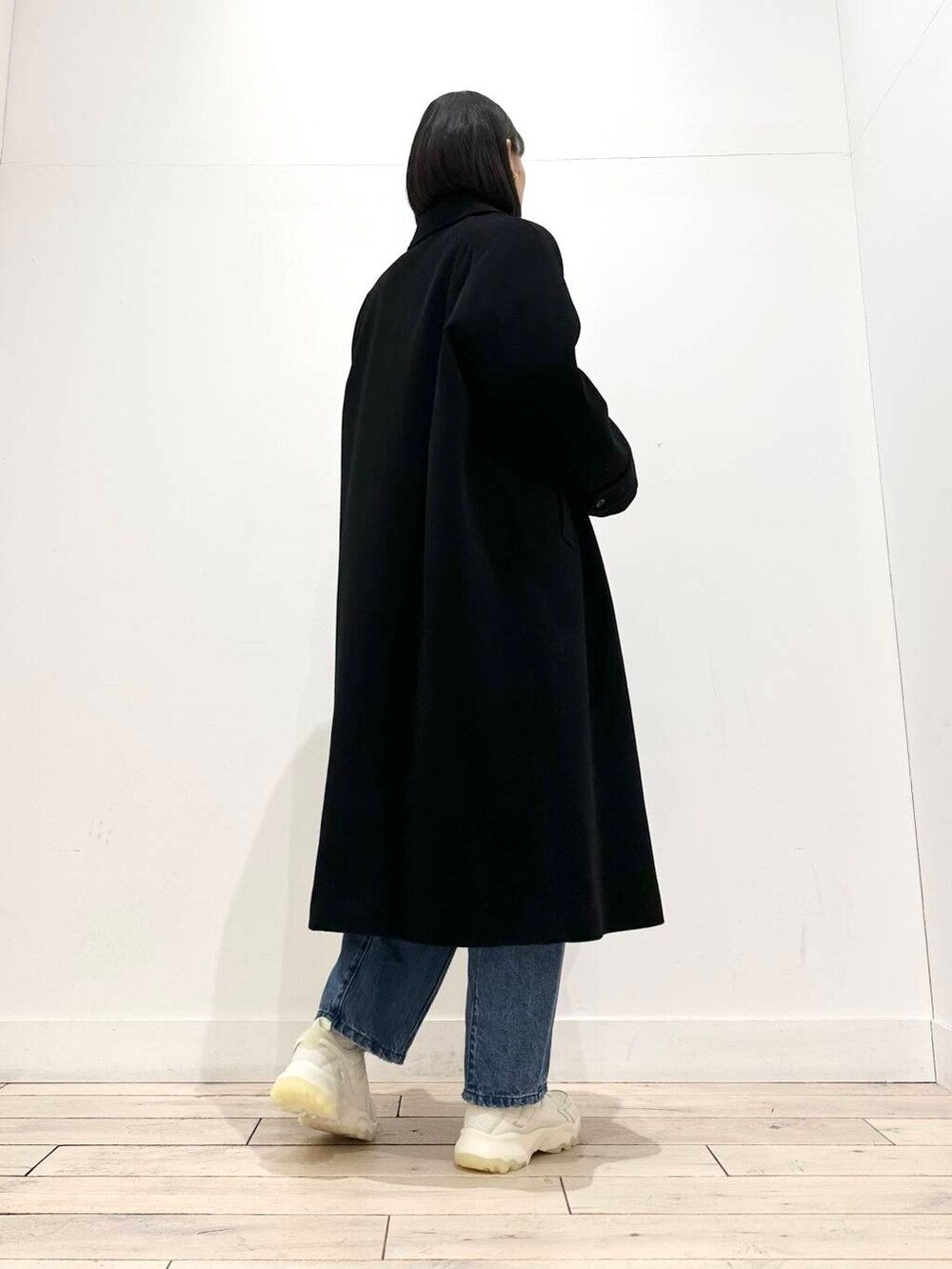 ブラック系のショルダーバッグ、ホワイト系のスニーカー、ブラック系のその他アウターを着用したレディースの冬コーディネートの7枚目の写真