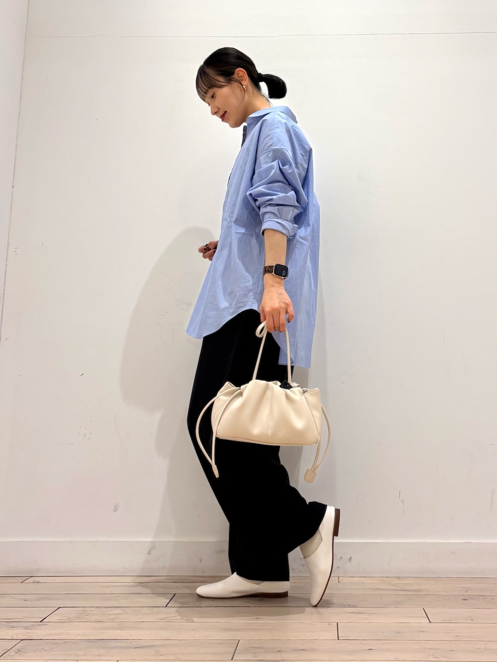 ブルー系のシャツ/ブラウス、ブラック系のその他パンツ、ホワイト系のショルダーバッグを着用したレディースの春コーディネートの2枚目の写真