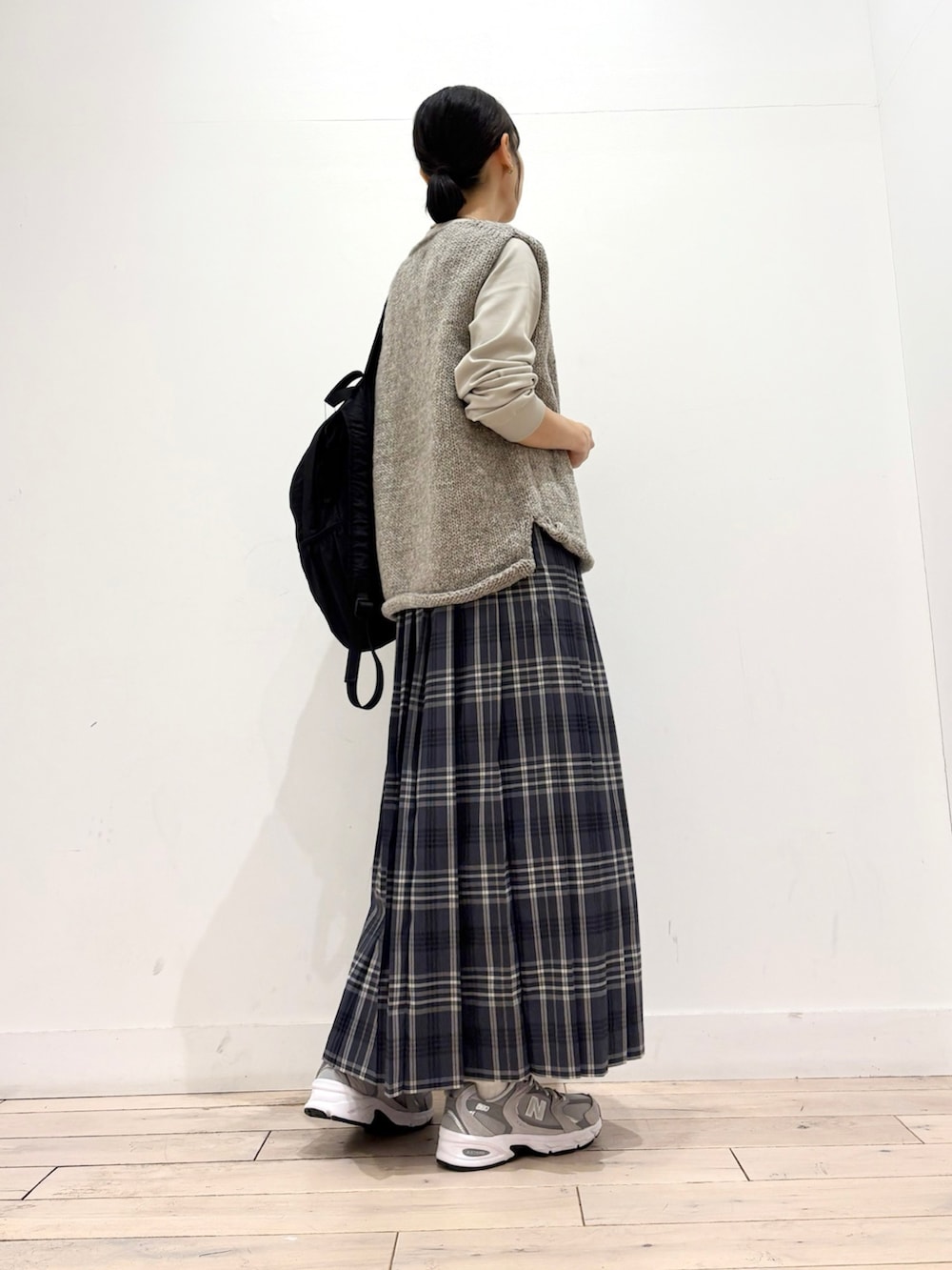 ベージュ系のTシャツ/カットソー、グレー系のニット/セーター、グレー系のスカートを着用したレディースの秋コーディネートの3枚目の写真