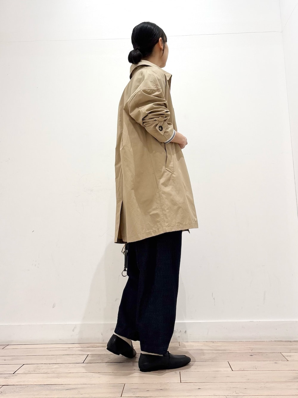 ブルー系のTシャツ/カットソー、ベージュ系のステンカラーコート、ブルー系のデニムパンツを着用したレディースの春コーディネートの4枚目の写真