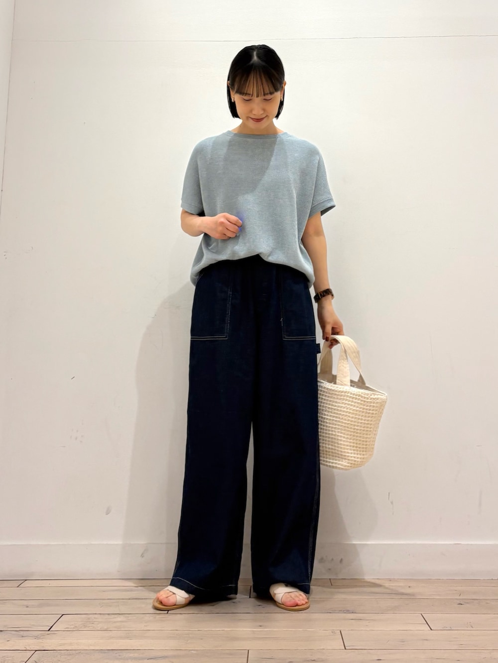 ブルー系のTシャツ/カットソー、ブルー系のデニムパンツ、ホワイト系のトートバッグを着用したレディースの春コーディネートの2枚目の写真