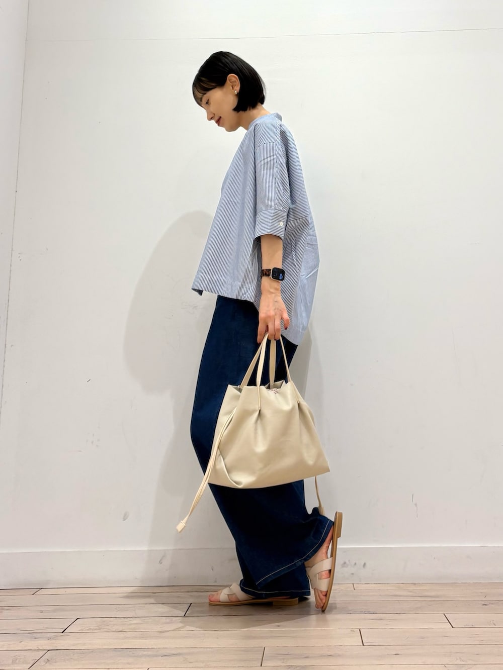 ホワイト系のタンクトップ、ブルー系のシャツ/ブラウス、ブルー系のデニムパンツを着用したレディースの春コーディネートの3枚目の写真