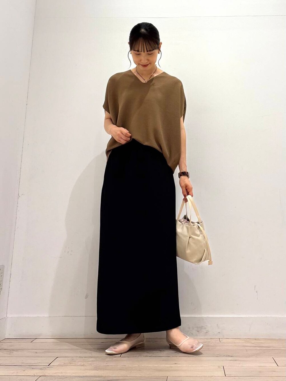 ホワイト系のバレエシューズ、ブラック系のスカート、ホワイト系のショルダーバッグを着用したレディースの夏コーディネートの2枚目の写真