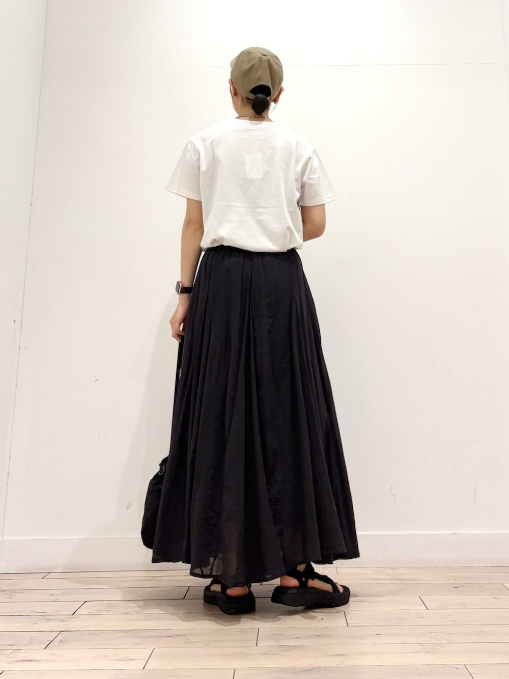 ホワイト系のTシャツ/カットソー、ブラック系のスカート、ブラック系のショルダーバッグを着用したレディースの夏コーディネートの4枚目の写真