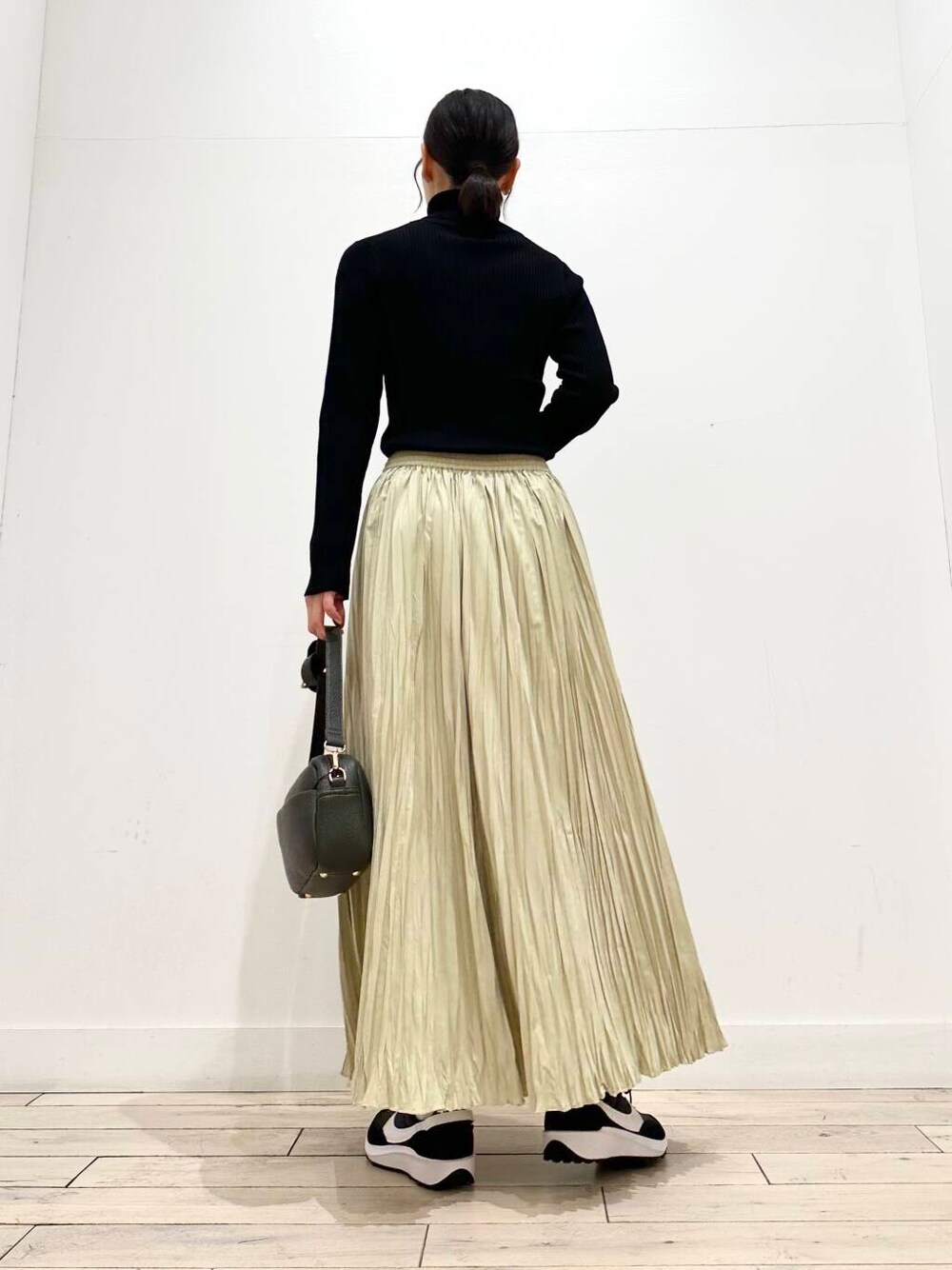 グリーン系のショルダーバッグ、ブラック系のその他アウター、ブラック系のニット/セーターを着用したレディースの冬コーディネートの5枚目の写真