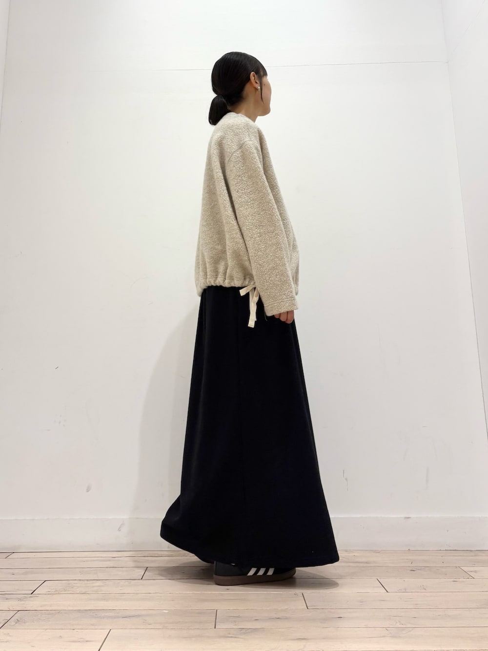 ベージュ系のTシャツ/カットソー、ブラック系のボストンバッグ、ブラック系のスニーカーを着用したレディースの秋コーディネートの2枚目の写真