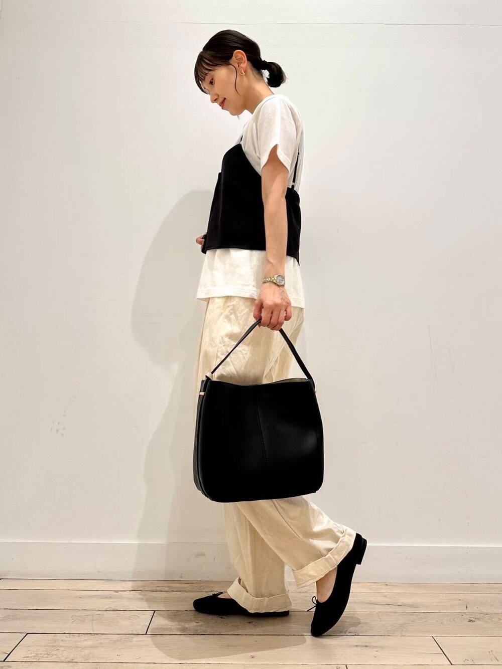 ホワイト系のTシャツ/カットソー、ブラック系のバレエシューズ、ベージュ系のデニムパンツを着用したレディースの夏コーディネートの2枚目の写真