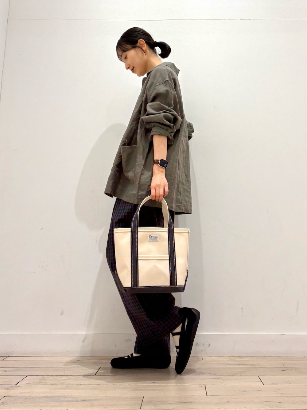 ホワイト系のタンクトップ、グレー系のカバーオール、グレー系のトートバッグを着用したレディースの春コーディネートの4枚目の写真