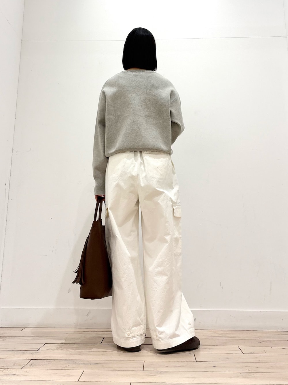 ベージュ系のニット/セーター、ベージュ系のトレンチコート、ブラウン系のトートバッグを着用したレディースの冬コーディネートの7枚目の写真