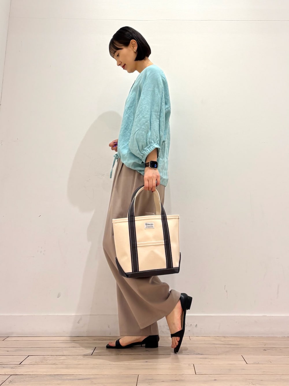 グリーン系のシャツ/ブラウス、ベージュ系のその他パンツ、グレー系のトートバッグを着用したレディースの春コーディネートの3枚目の写真