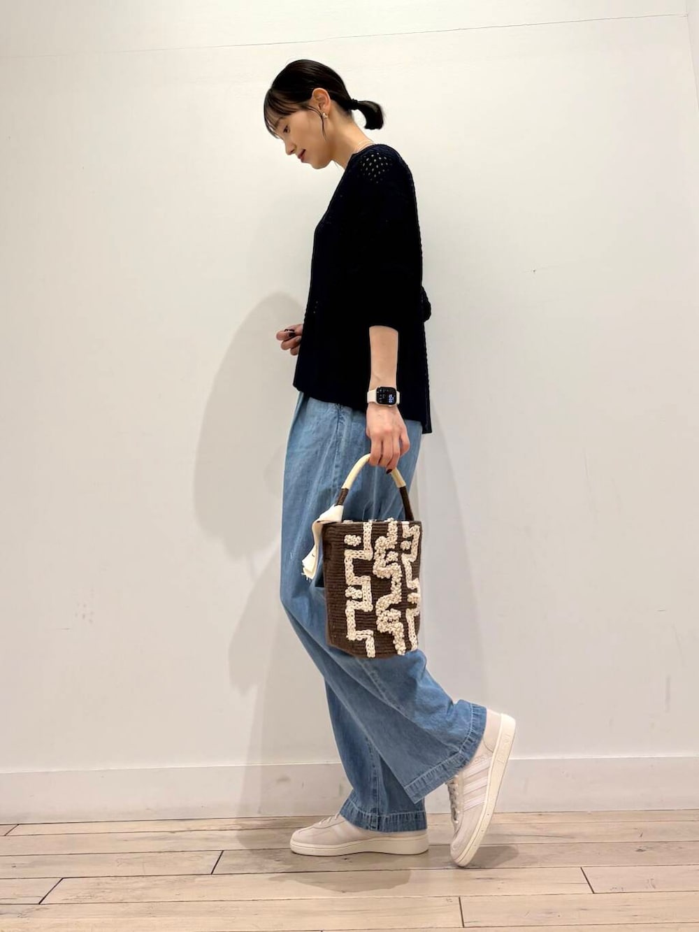 グリーン系のミリタリージャケット、ブルー系のデニムパンツ、ブルー系のカーディガン/ボレロを着用したレディースの春コーディネートの3枚目の写真