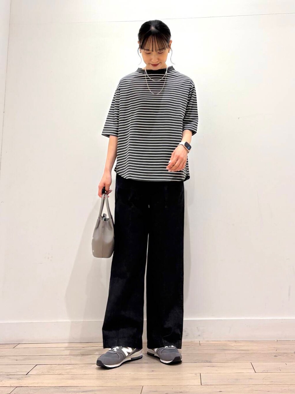 ベージュ系のマウンテンパーカー、ブラック系のデニムパンツ、グレー系のショルダーバッグを着用したレディースの春コーディネートの5枚目の写真