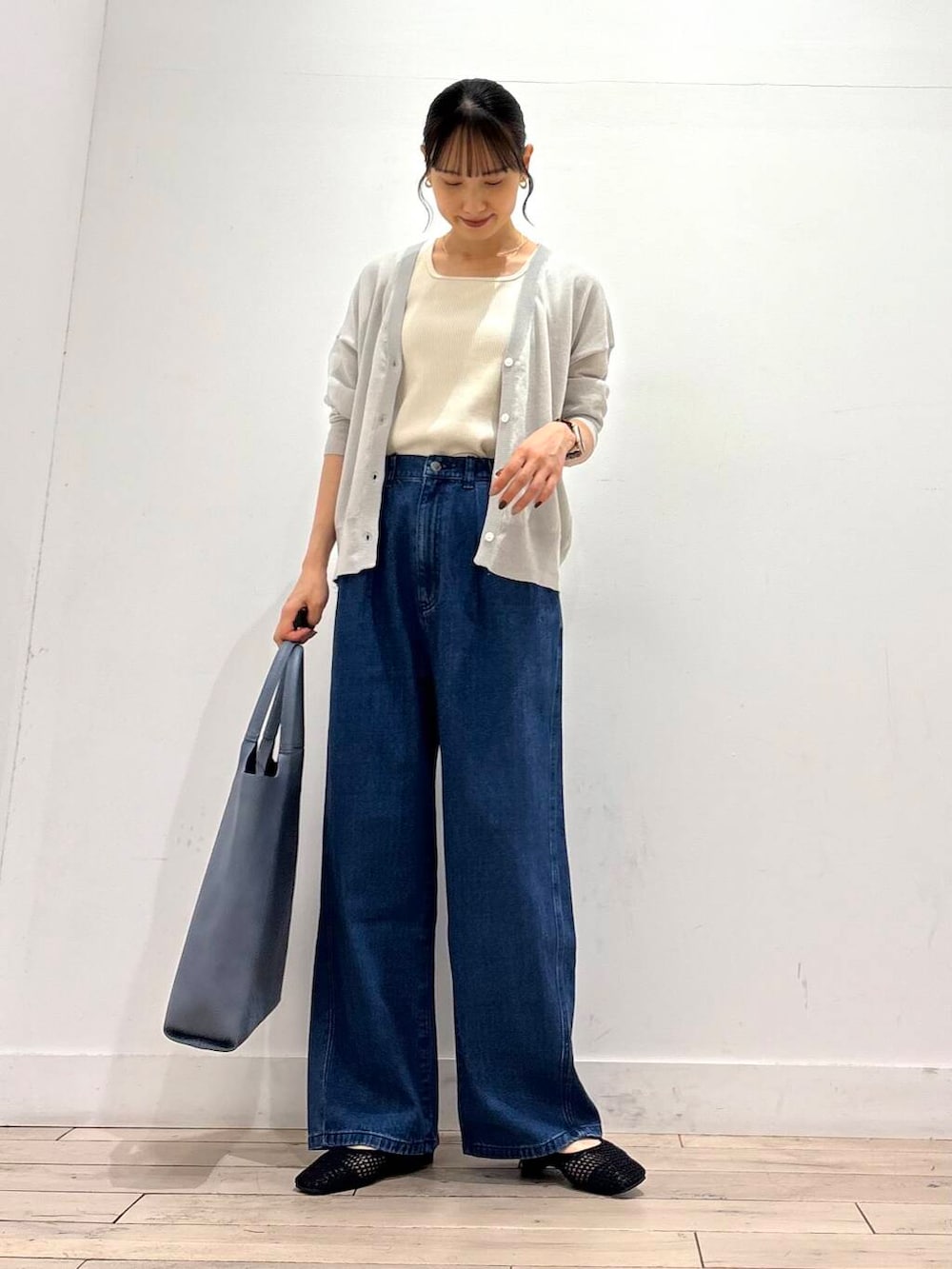 ブルー系のデニムパンツ、ブルー系のトートバッグ、グレー系のカーディガン/ボレロを着用したレディースの夏コーディネートの3枚目の写真