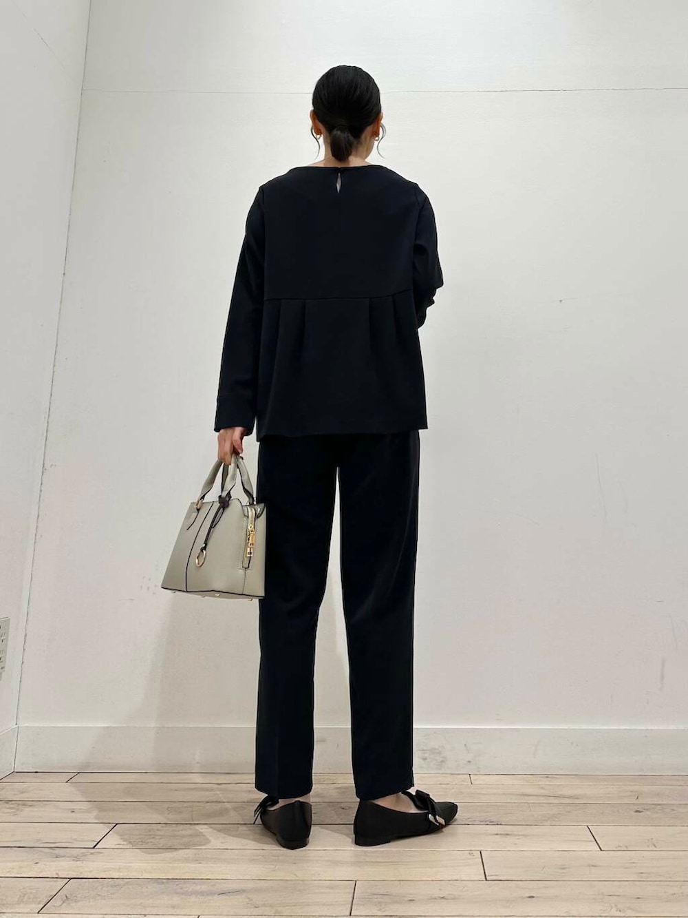 ブラック系のドレスシューズ、グレー系のハンドバッグ、ブルー系のセットアップを着用したレディースの冬コーディネートの6枚目の写真