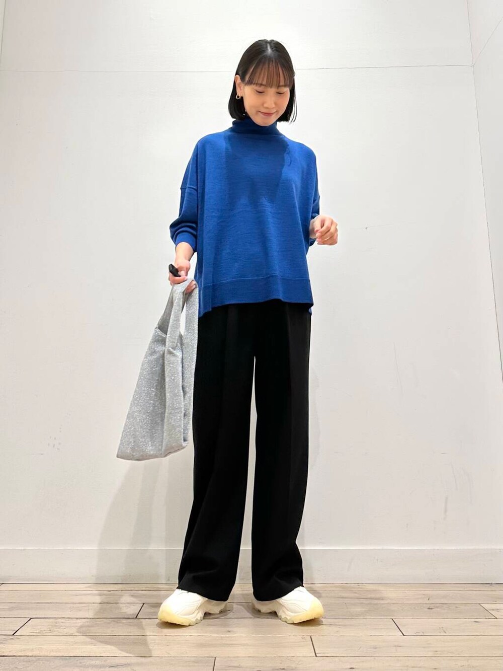 ホワイト系のスニーカー、グリーン系のニット/セーター、シルバー系のトートバッグを着用したレディースの冬コーディネートの4枚目の写真