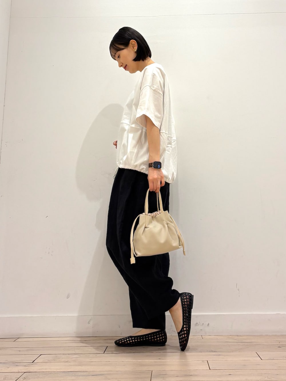 ホワイト系のTシャツ/カットソー、ブラック系のその他パンツ、ブラック系のサンダルを着用したレディースの春コーディネートの2枚目の写真