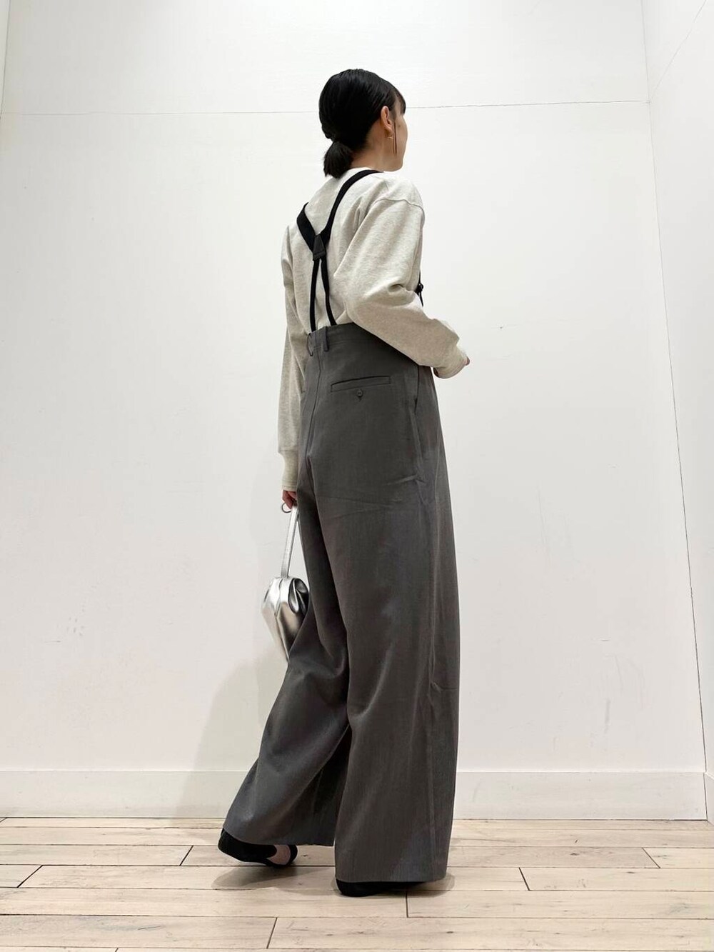 ブラック系のブルゾン、グレー系のその他パンツ、シルバー系のショルダーバッグを着用したレディースの冬コーディネートの2枚目の写真