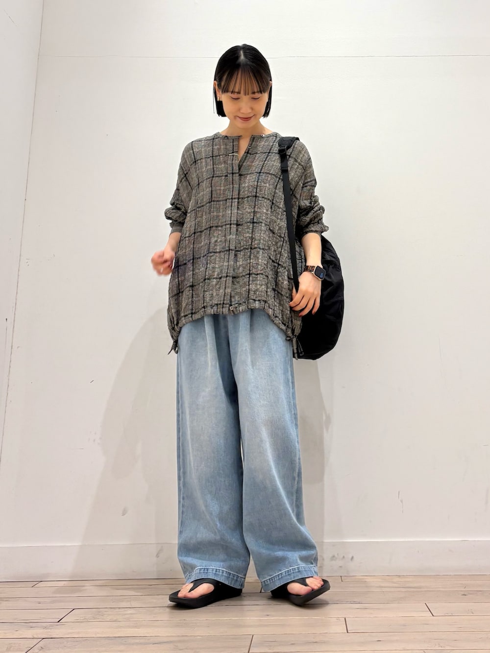 ブラック系のシャツ/ブラウス、ブルー系のデニムパンツ、ブラック系のサンダルを着用したレディースの春コーディネートの2枚目の写真