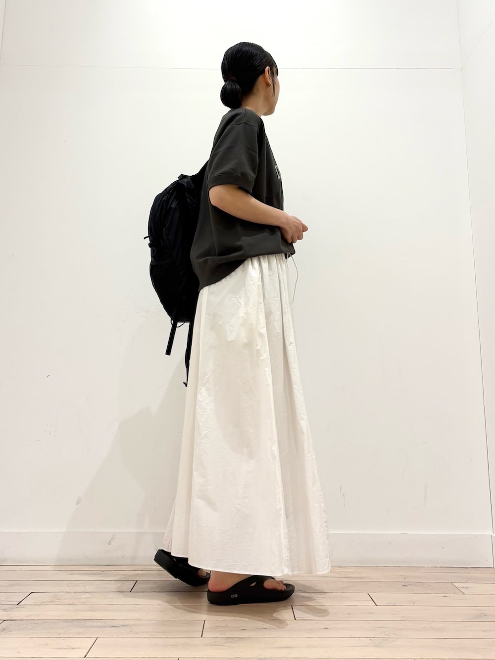 ブラック系のスウェット、ブラック系のサンダル、ブラック系のバックパック/リュックを着用したレディースの春コーディネートの3枚目の写真