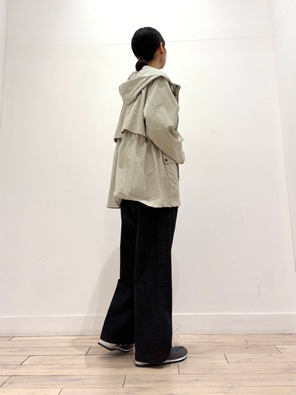 ベージュ系のマウンテンパーカー、ブラック系のデニムパンツ、グレー系のショルダーバッグを着用したレディースの春コーディネートの2枚目の写真