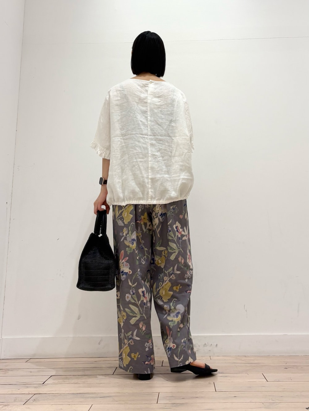 ホワイト系のシャツ/ブラウス、グレー系のその他パンツ、ブラック系のハンドバッグを着用したレディースの春コーディネートの4枚目の写真