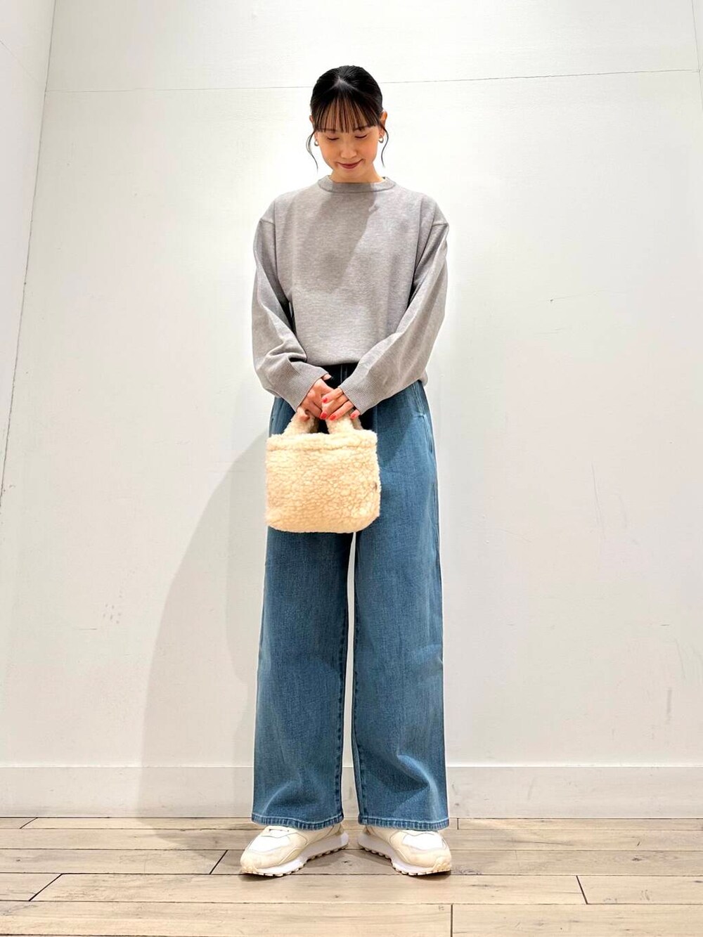 ホワイト系のスニーカー、ブルー系のその他アウター、ベージュ系のハンドバッグを着用したレディースの冬コーディネートの4枚目の写真