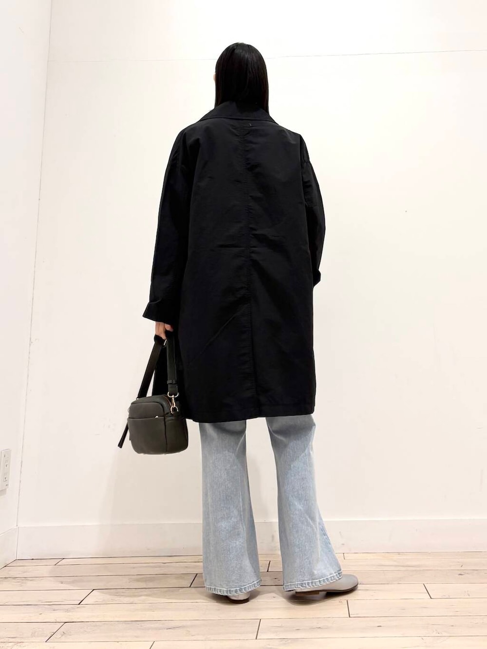 グリーン系のショルダーバッグ、シルバー系のパンプス、ブルー系のデニムパンツを着用したレディースの春コーディネートの8枚目の写真