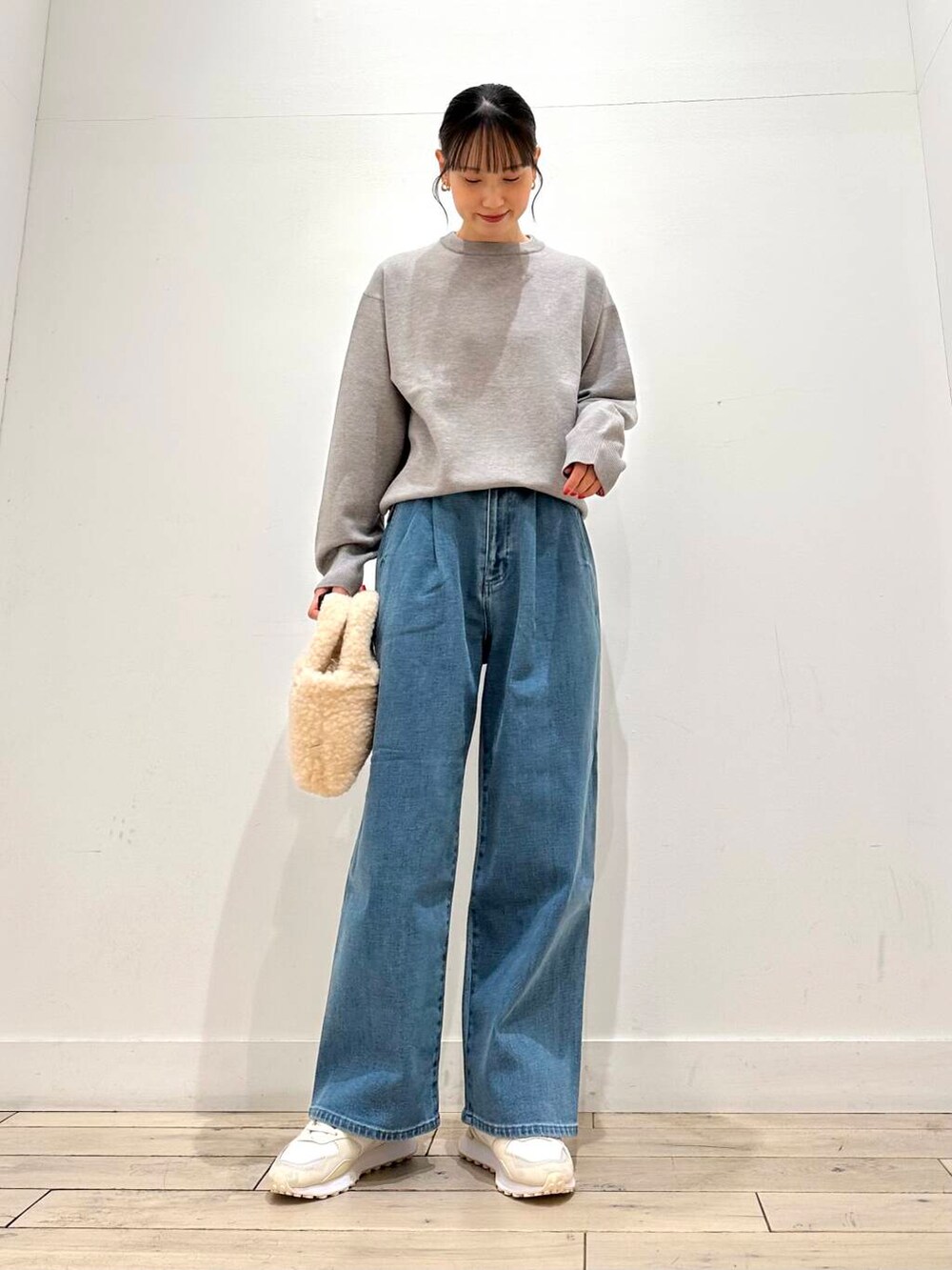 ホワイト系のスニーカー、ブルー系のその他アウター、ベージュ系のハンドバッグを着用したレディースの冬コーディネートの5枚目の写真