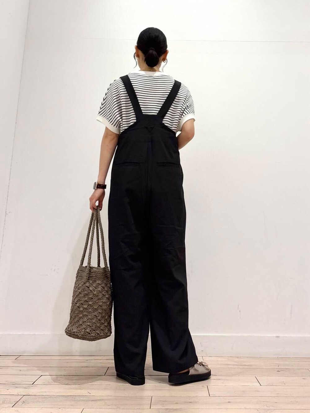 グレー系のトートバッグ、グレー系のサンダル、ブラック系のその他パンツを着用したレディースの夏コーディネートの3枚目の写真