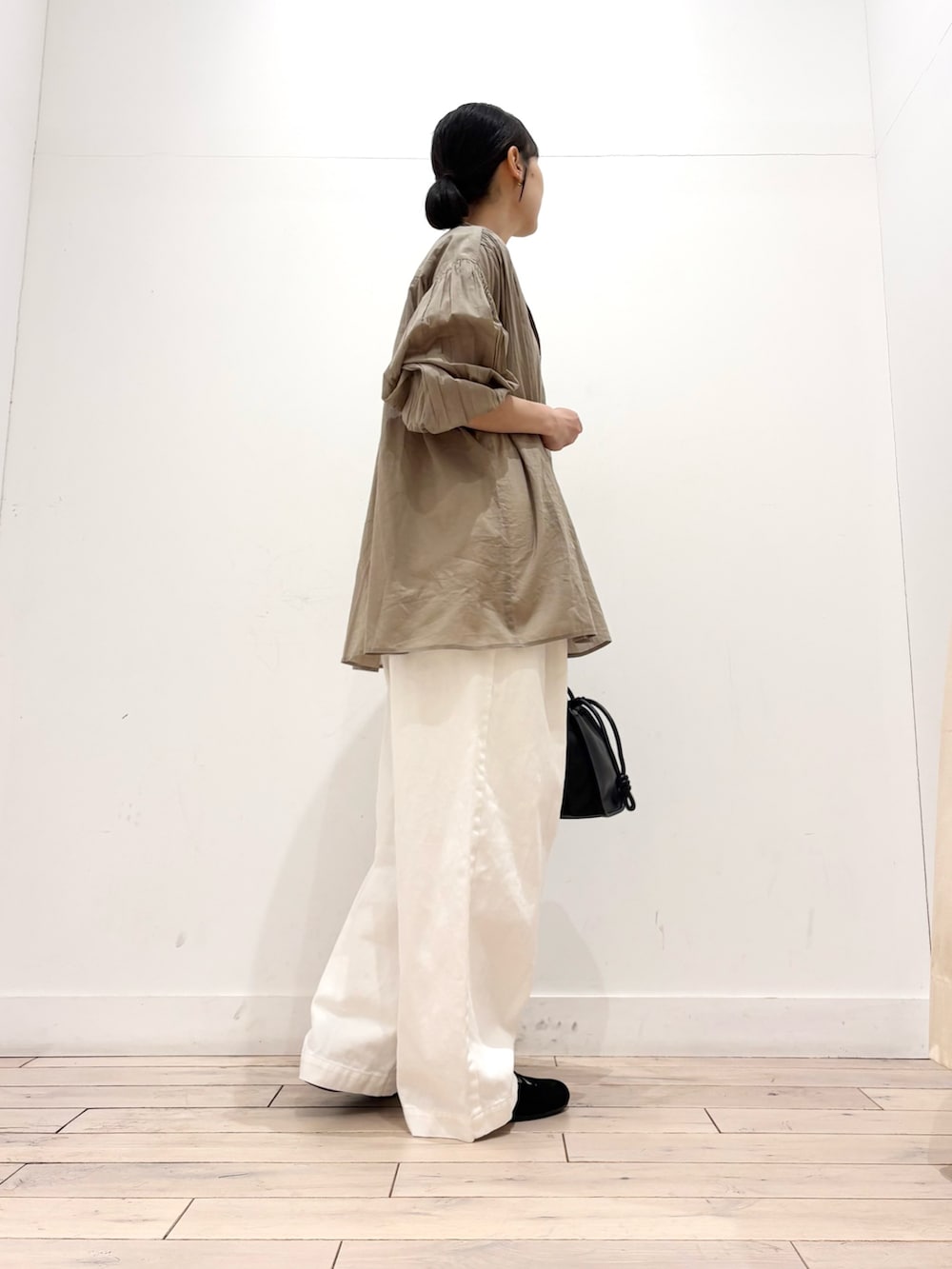 ホワイト系のタンクトップ、ベージュ系のシャツ/ブラウス、ブラック系のトートバッグを着用したレディースの春コーディネートの4枚目の写真