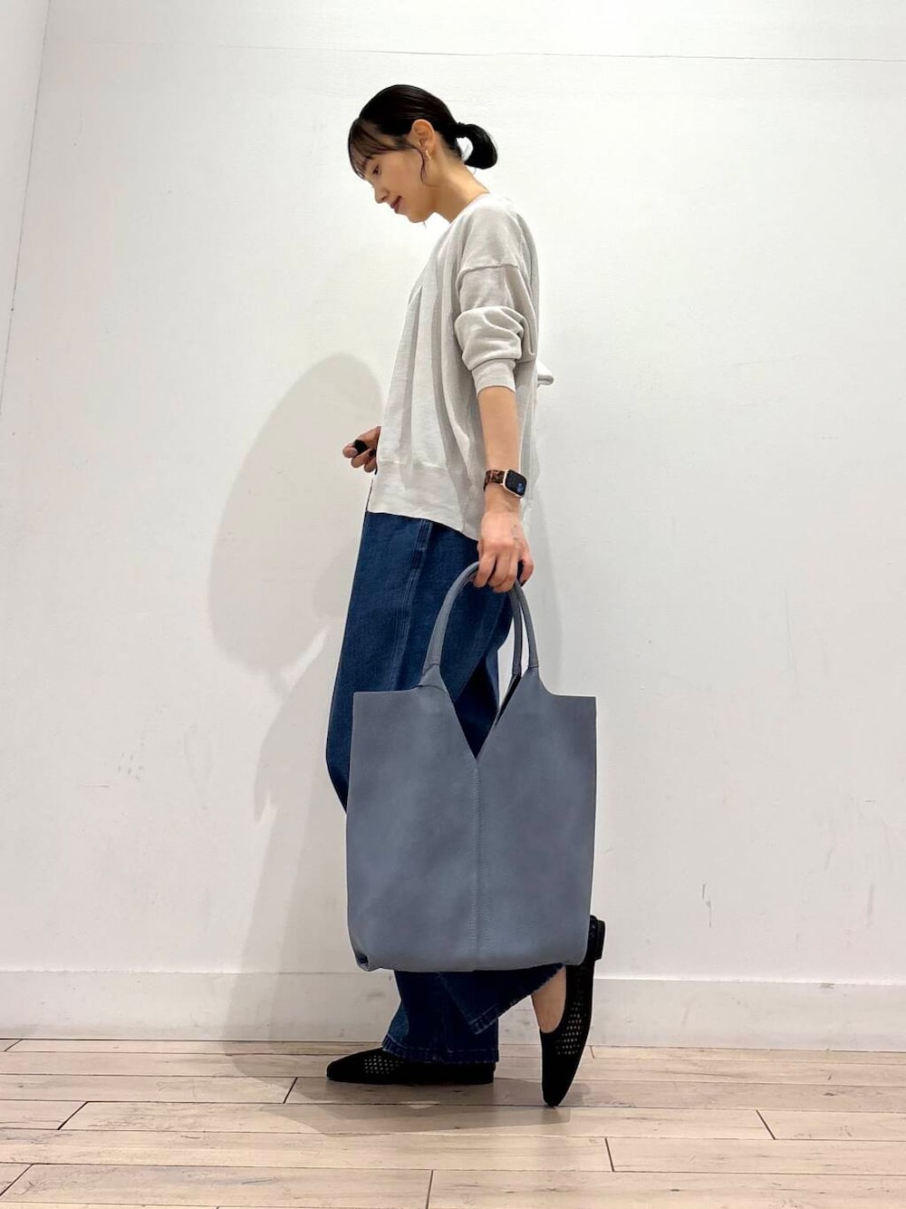 ブルー系のデニムパンツ、ブルー系のトートバッグ、グレー系のカーディガン/ボレロを着用したレディースの夏コーディネートの4枚目の写真