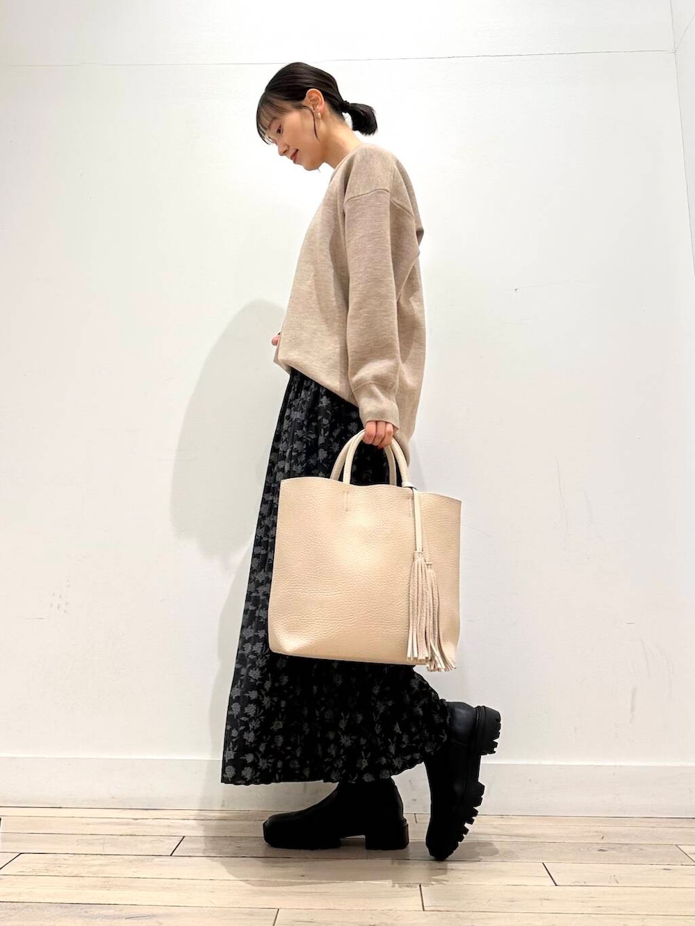 ホワイト系のトートバッグ、ブルー系のその他アウター、ブラック系のブーツを着用したレディースの冬コーディネートの6枚目の写真