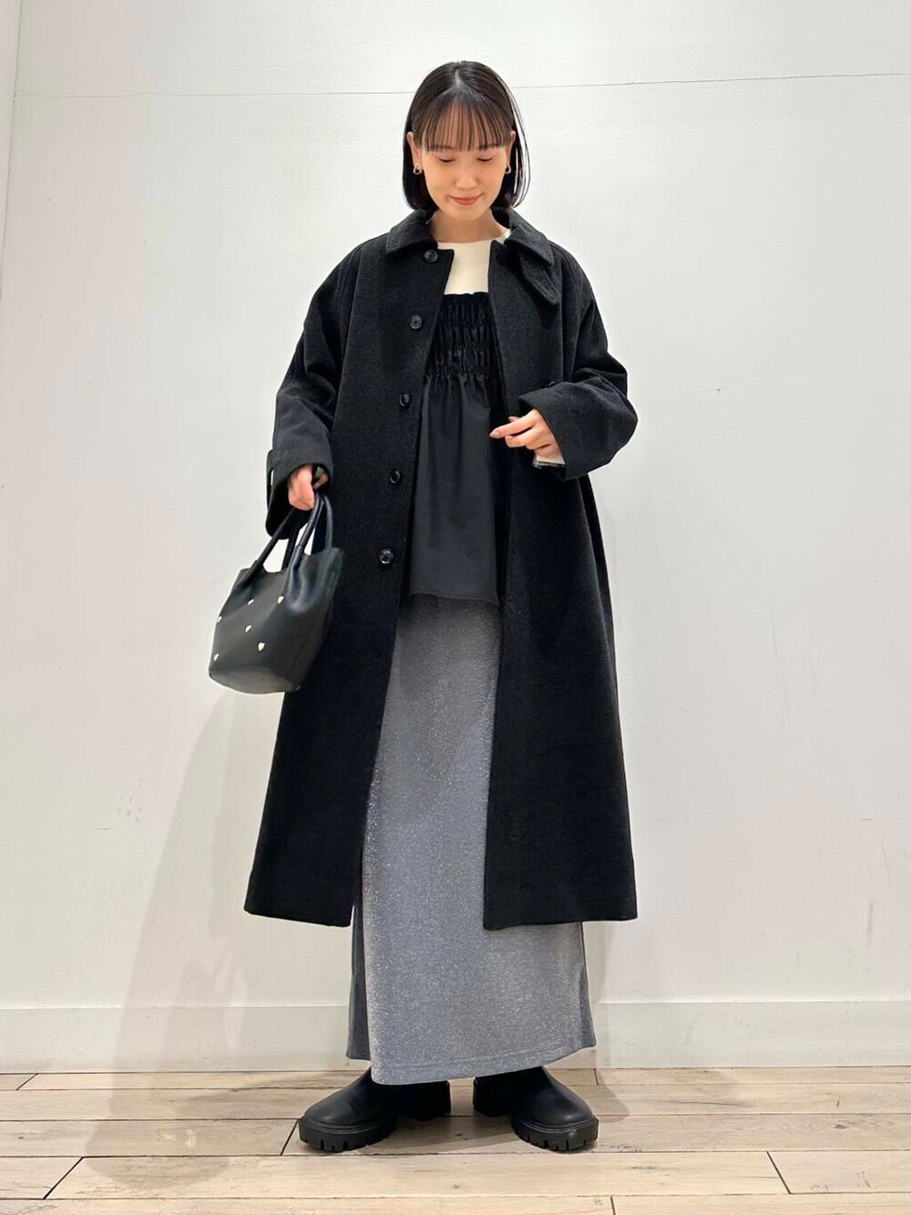 グレー系のその他アウター、ブラック系のブーツ、グレー系のスカートを着用したレディースの冬コーディネートの4枚目の写真