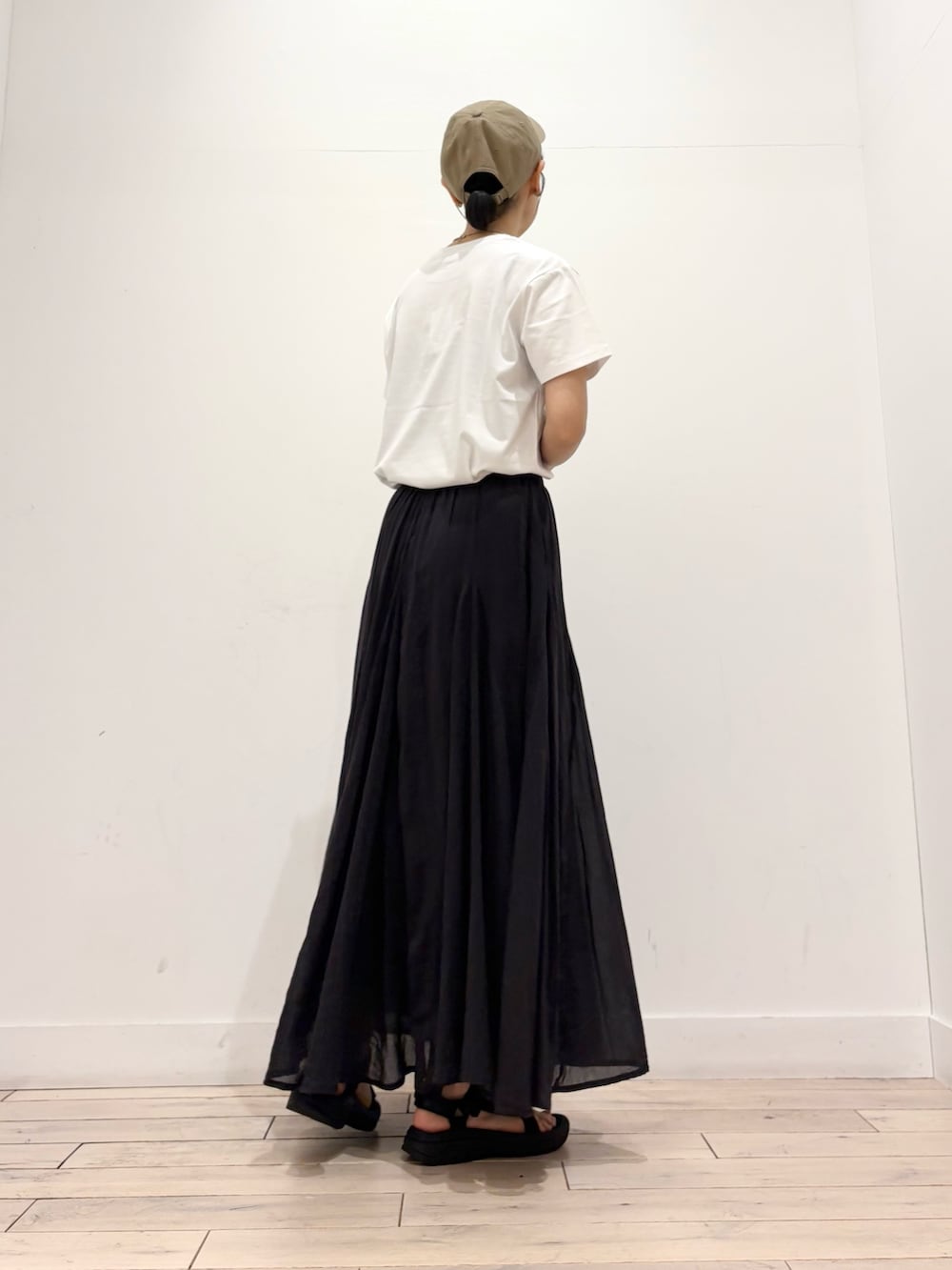 ホワイト系のTシャツ/カットソー、ブラック系のスカート、ブラック系のショルダーバッグを着用したレディースの夏コーディネートの3枚目の写真
