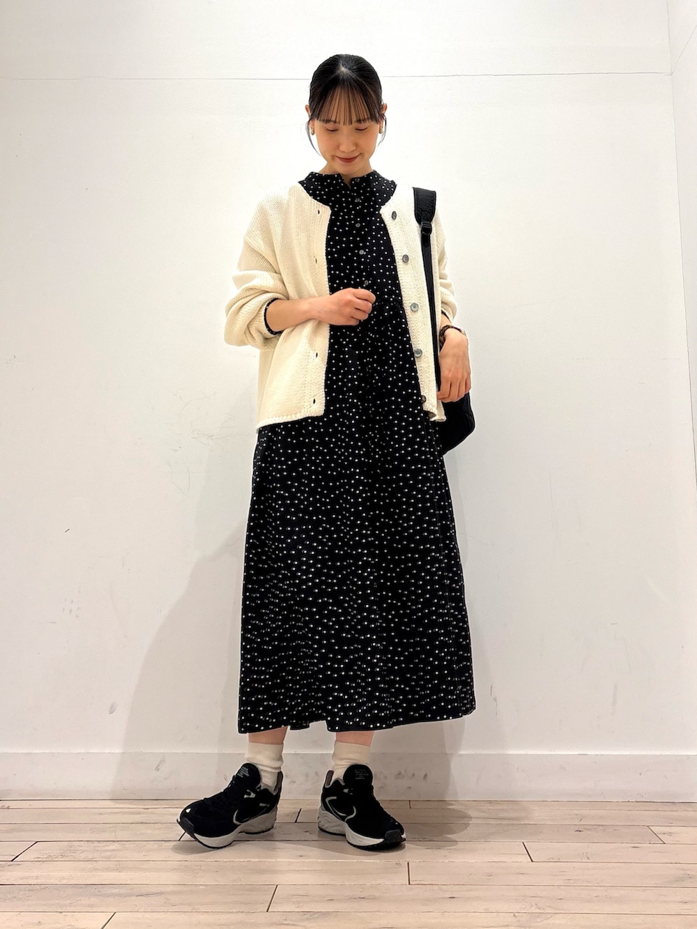 ホワイト系のカーディガン/ボレロ、ブラック系のワンピース、ブラック系のスニーカーを着用したレディースの春コーディネートの2枚目の写真